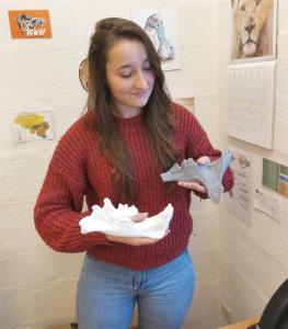 Narimane Chatar holding casts of mandibles from Smilodon and Barbourufelis.